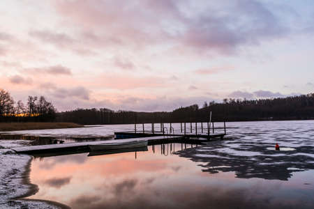 Small marina with boat on the lake at sunrise.の写真素材