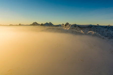 Illuminated by the rising sun fog clouds in the Tatra Mountains.