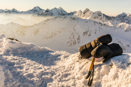 Ice axe and mittens with mountains in the background.の写真素材