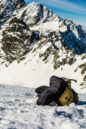 Mittens, ice axe and helmet in the mountains.の写真素材