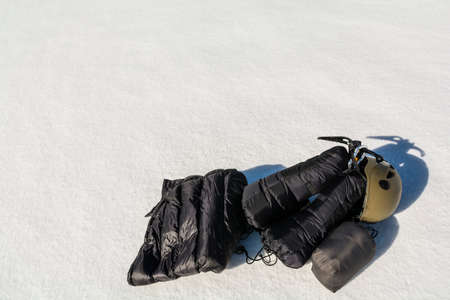 Clothing down, ice axe and helmet on the snow.の写真素材