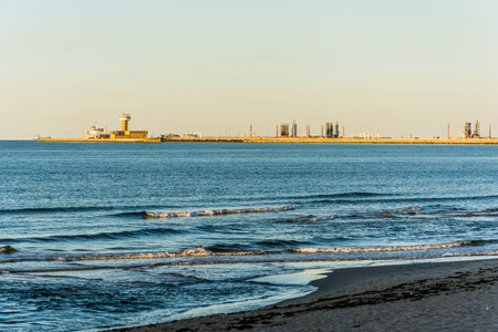 Gdansk Bay - industrial infrastructure on the waterfront in the rays of the setting sun.