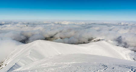 Dark puffy clouds covering the lowlands seen from the slopes of the mountains.の写真素材