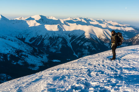 Hiker with backpack on the background of a winter mountain landscape.