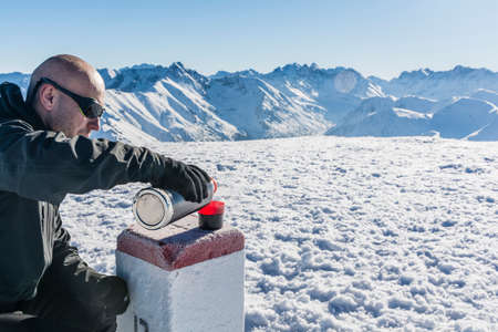 Tourist pours hot tea in the mountains. As the table is a boundary.の写真素材