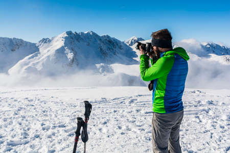 Tourist does photo camera to the mountain landscape in winter.の写真素材