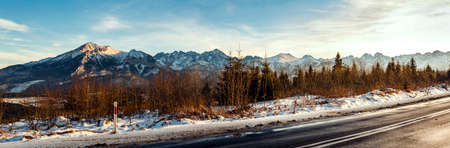 View from asphalt road to snow-capped mountain peaks.の写真素材