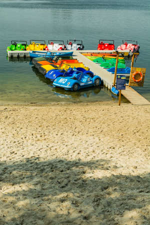 Kryspinow, Poland - September 10, 2017: Paddle boat in the shape of cars moored at a summer walkway on a lake.のeditorial素材