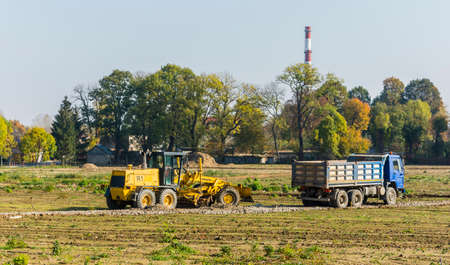 Niedomice, Poland - October 19, 2017: Grader and truck on the construction site.のeditorial素材