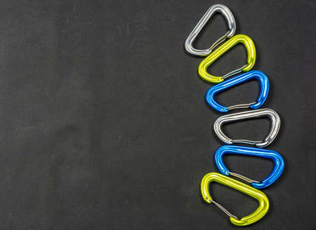 Set of six colorful carabiners climbing from a wire gate.の写真素材
