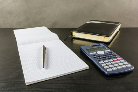Notes for saving calculation results from a calculator on a dark desk.