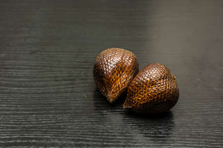 Salak also called snake fruit on a dark wooden substrate.の写真素材