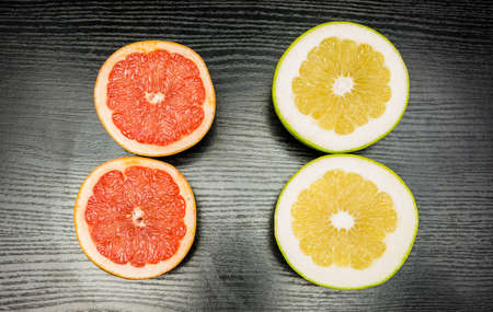 Comparison on a dark background of green and pink grapefruit pulp.の写真素材