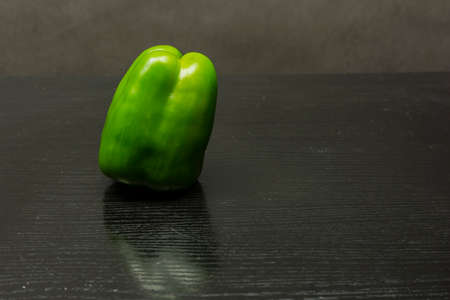 Green pepper (Capsicum annuum) on a wooden table.の写真素材
