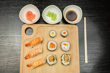 Board with a traditional sushi set and dishes with wasabi soy sauce marinated with ginger.の写真素材