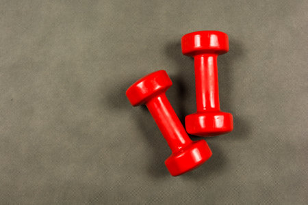 Red dumbbells for fitness or rehabilitation with a weight of three kilograms.