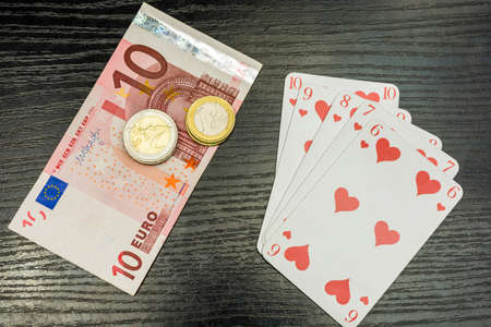Poker - Straight flush, money and euro coins on the table.の写真素材