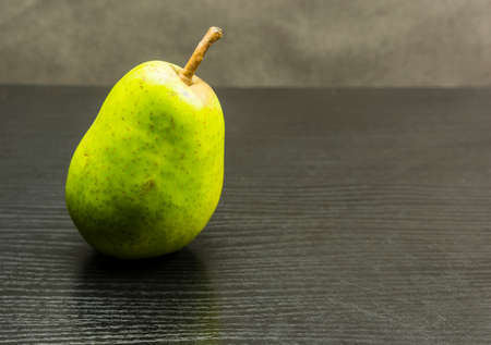 Tasty ripe pear on a wooden dark table.の写真素材