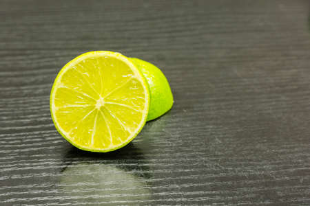 Half a lime fruit on a wooden dark table.の写真素材