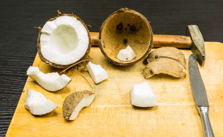 Coconut and tools for its opening on the board.の写真素材