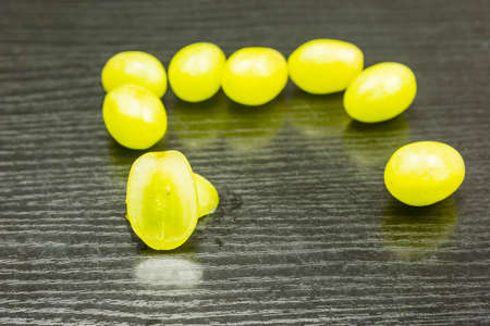 Cut white grape on the table and whole fruits in the background.の写真素材