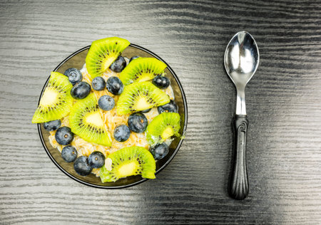Oatmeal with blueberries and kiwi fruit on the table.