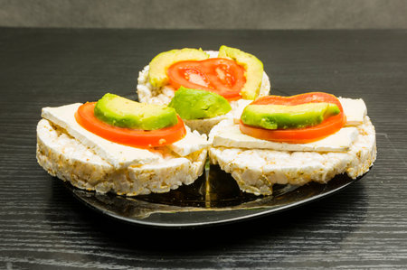 Plate with healthy and dietary sandwiches - rice cake with cheese, tomato and avocado.の写真素材