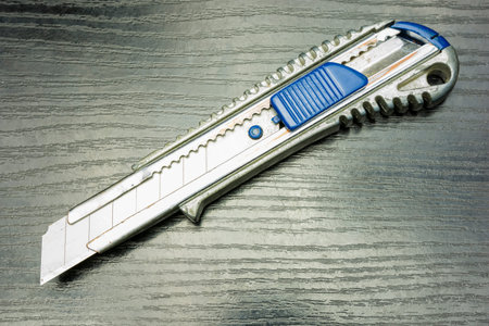 Segmented blade or snap-off blade utility knife on a wooden table.