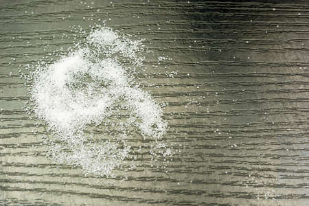 Salt spilled on a wooden table as texture.の写真素材