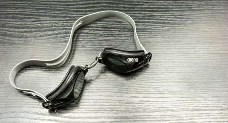 Niedomice, Poland - January 22, 2018: Swimming goggles - Arena, on a wooden dark basis.のeditorial素材