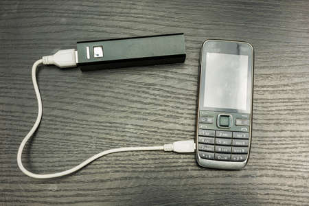 Powerbank charging a discharged mobile phone.の写真素材