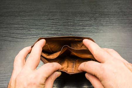 The person looks into the empty wallet being held.の写真素材