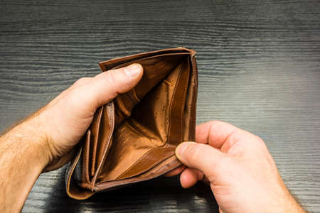 The man looks into the empty wallet he is holding.の写真素材