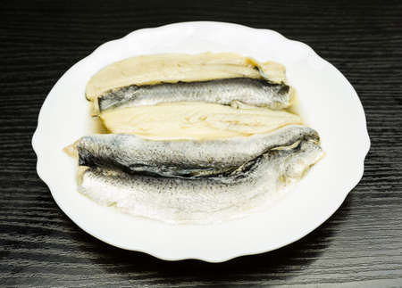 White plate with marinated herring in oil.の写真素材