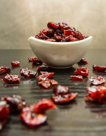 Dried cranberry scattered on the table and in a bowl.の写真素材