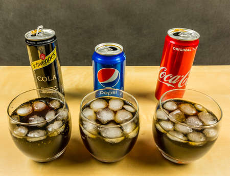 Niedomice, Poland - March 09, 2018: A cola carbonated drink made by Pepsi, Coca-Cola and Schweppes. presented in glasses with ice cubes.のeditorial素材