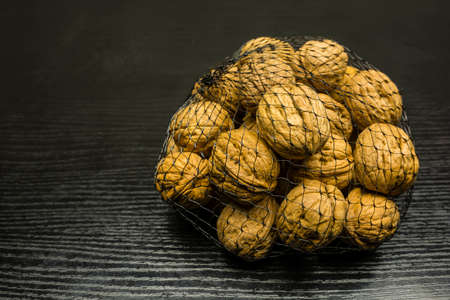 A grid with whole walnuts on the table.の写真素材