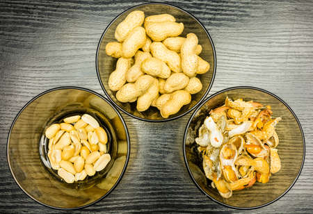 Shelling peanuts, nutshell in a bowl and clean peanuts on the plate. View from above.の写真素材