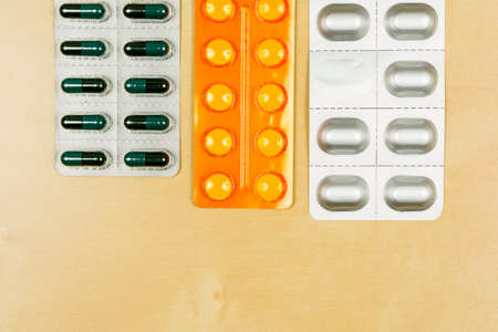 Different types of packaging (Blister pack) with tablets on a wooden background.の写真素材