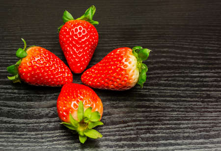 Red ripe fruit strawberries on a wooden background.の写真素材