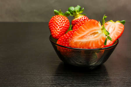 Bowl with red ripe strawberries on a wooden dark background.の写真素材