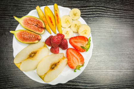 Top view of a plate with fresh, delicious and juicy fruit on the table.の写真素材