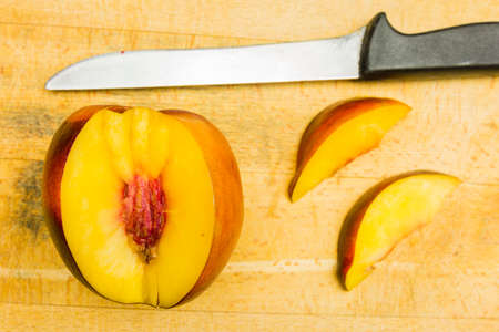Nectarines cut open on chopping board. View from above.の写真素材