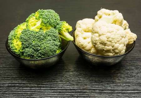 Fresh broccoli and cauliflower in a bowl on a dark background.の写真素材