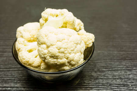 Fresh cauliflower in a bowl on a dark background.の写真素材