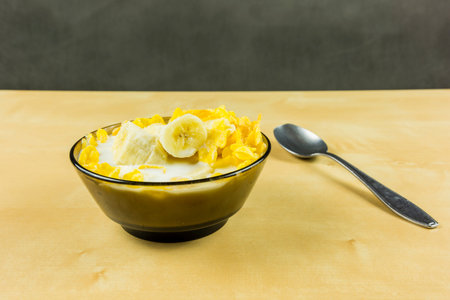 Corn flakes are usually served with cold milk and with fruit, for example, a banana.の写真素材