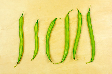 Green vegetable - Fresh pods, raw green beans on wooden board.