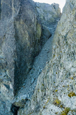 Dangerous loose rock in a steep gully, which leads one of the popular mountain roads to Starolesny Peak (Bradavica) in the Slovak Tatra mountains.の写真素材