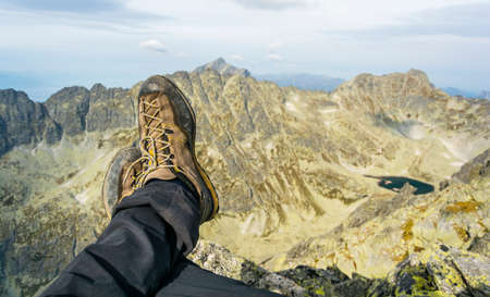 Legs of an alpine tourist with shoes approach on the background of mountains.の写真素材