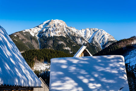 Kominiarski Wierch peak in the Western Tatras, view from the snowy roofs of huts in the Chocholowska...